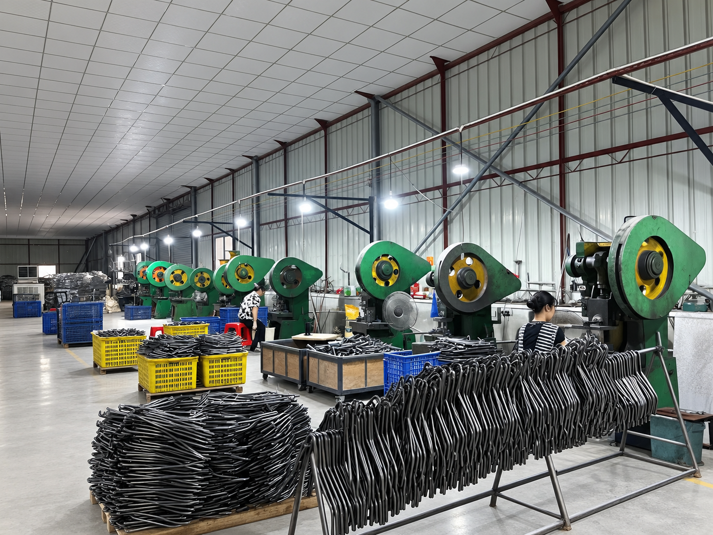 Operator processing metal tube components on industrial equipment
